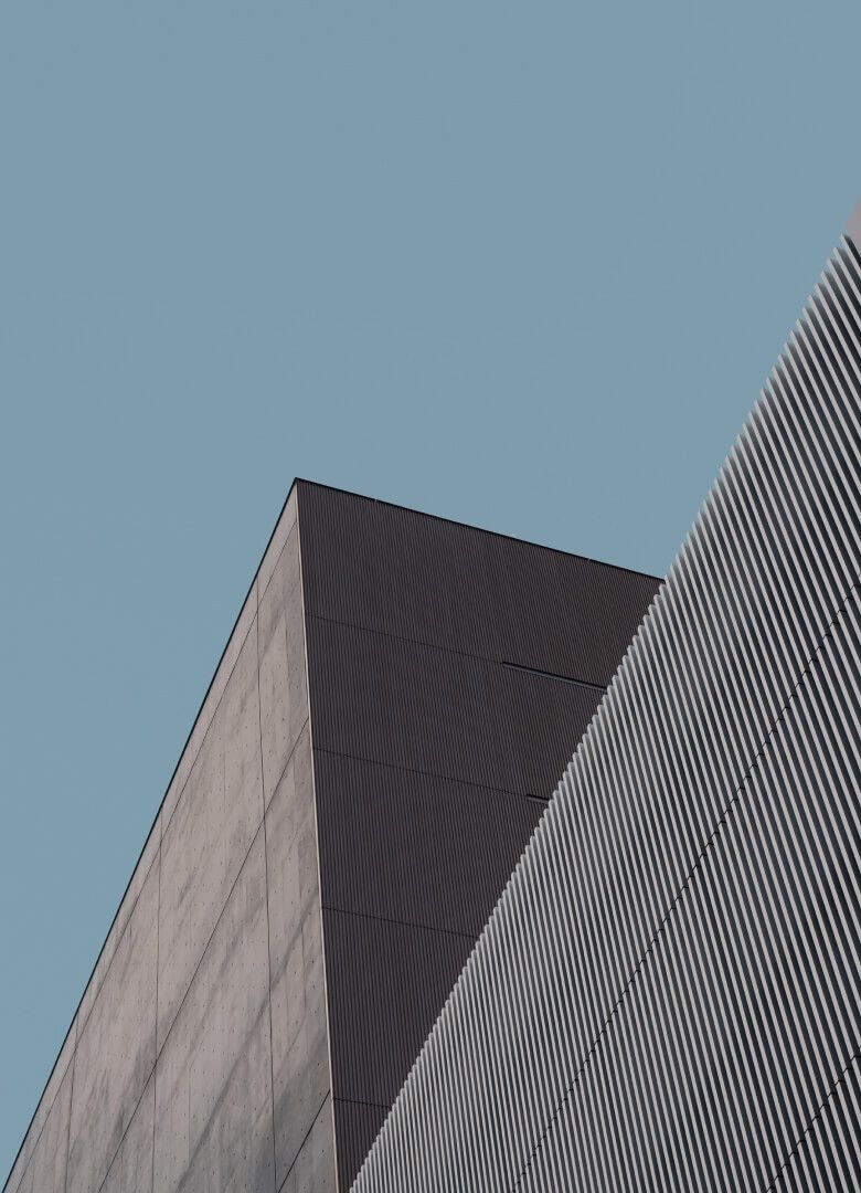 Sharp architectural angle of modern minimalist building under clear sky – Neutrinos