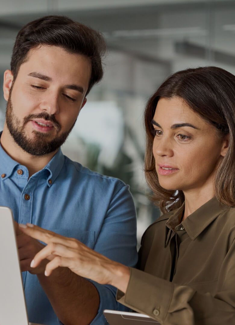 Two professionals discussing something on a laptop screen in an office setting-Neutrinos