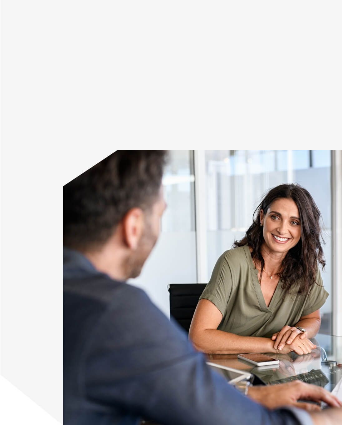 Businesswoman smiling during office discussion across glass desk – Neutrinos