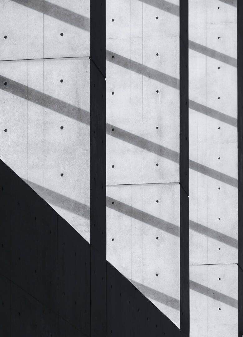 Minimalist concrete wall with geometric shadows and vertical lines in black and white-Neutrinos
