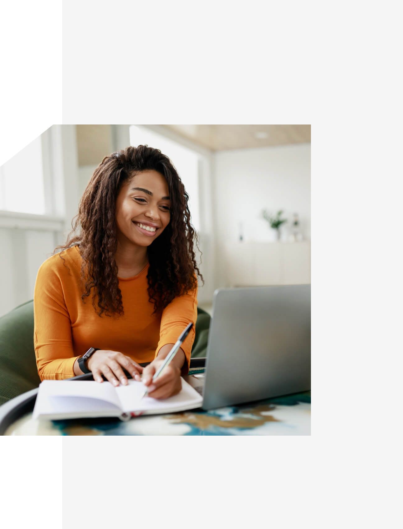 Smiling woman writing notes during an online session on her laptop – Neutrinos