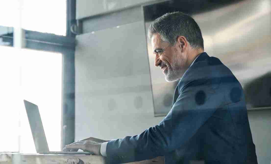 Professional man in a suit working on a laptop at a modern office desk-Neutrinos