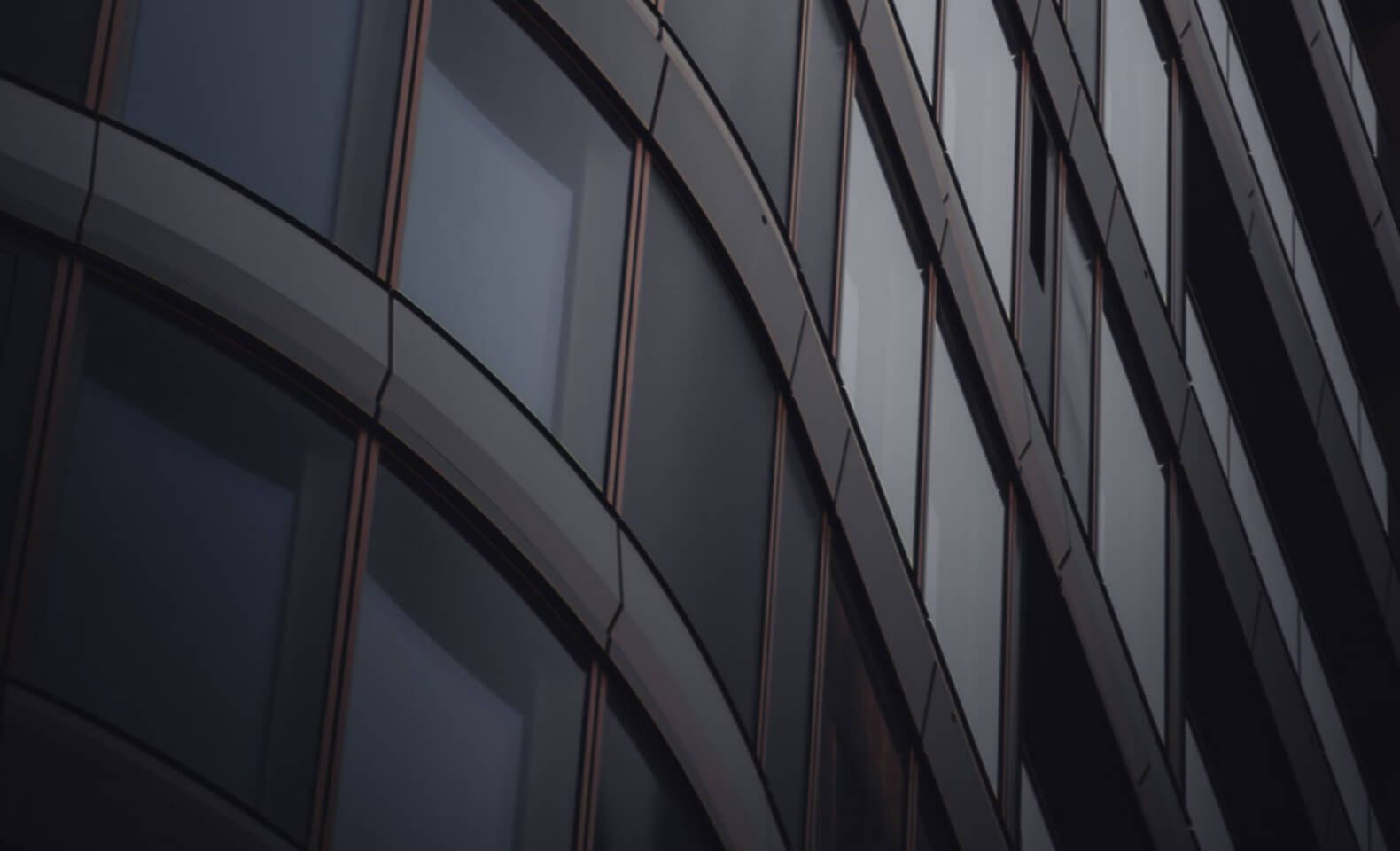Dark glass facade of a modern office building with curved architectural lines – Neutrinos.
