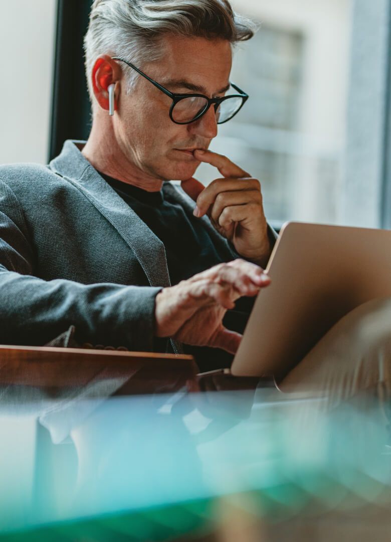 Focused professional using a laptop and wearing wireless earbuds-Neutrinos