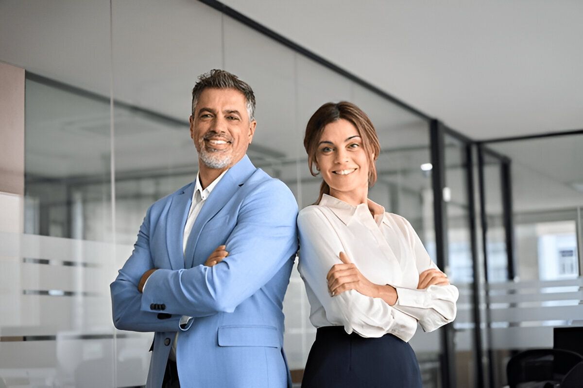 Confident business professionals standing side by side with arms crossed in a modern office, conveying leadership and collaboration – Neutrinos