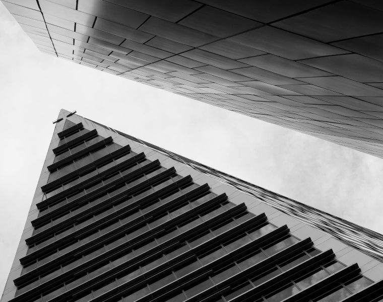 Low-angle view of modern high-rise buildings converging into the sky