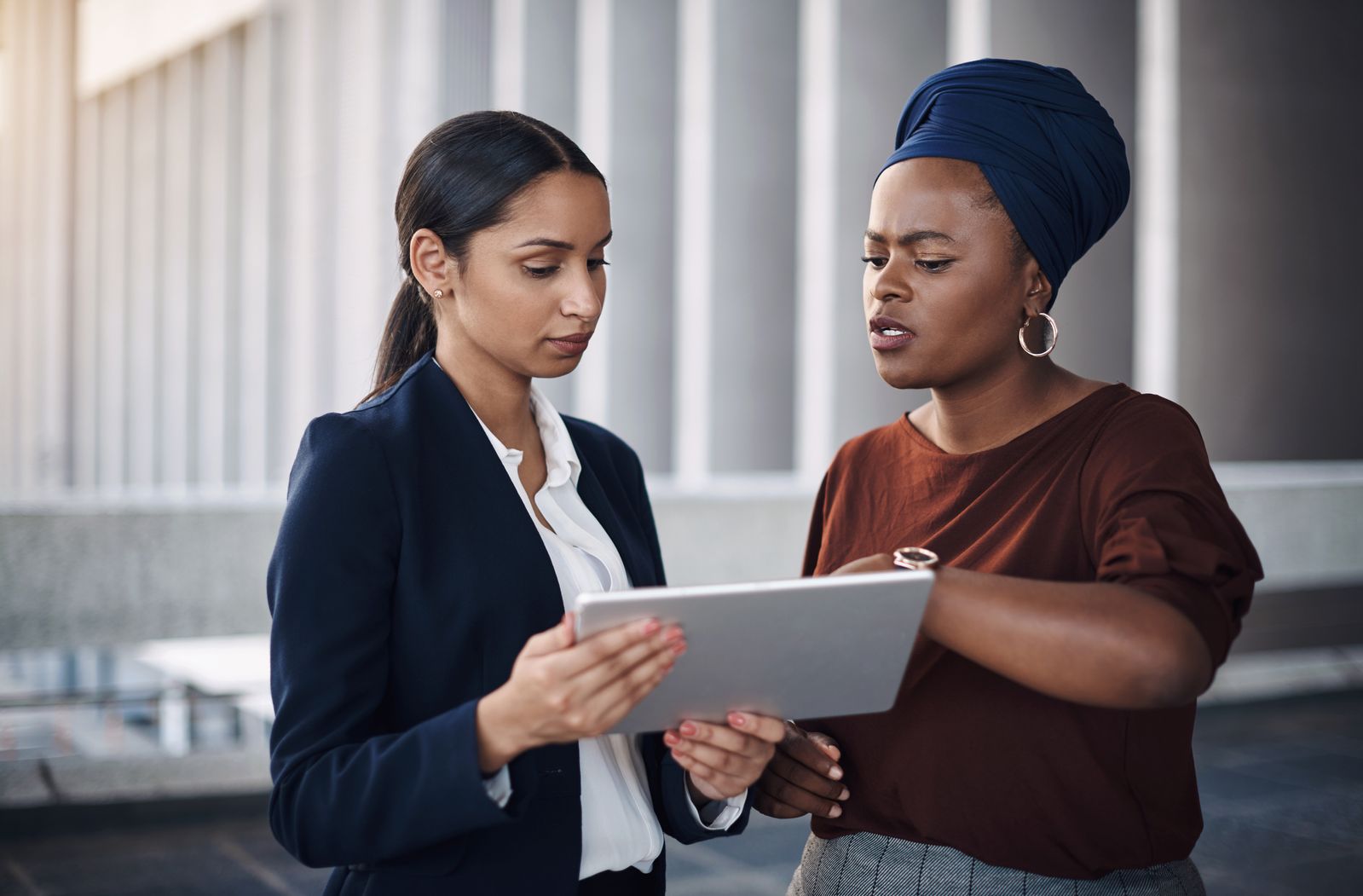 Talking, teamwork or business women on tablet in office for planning, review and company feedback. Media planner, balcony or manager in agency for networking online, social network update or news.