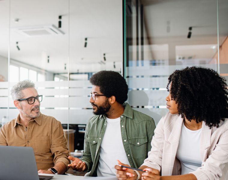 Three diverse professionals collaborating in a modern glass-walled office-Neutrinos