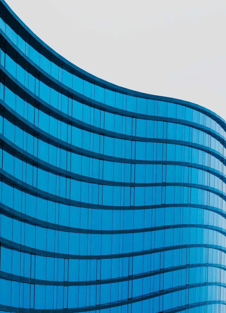 Curved blue glass facade of a modern office building against white background - Neutrinos